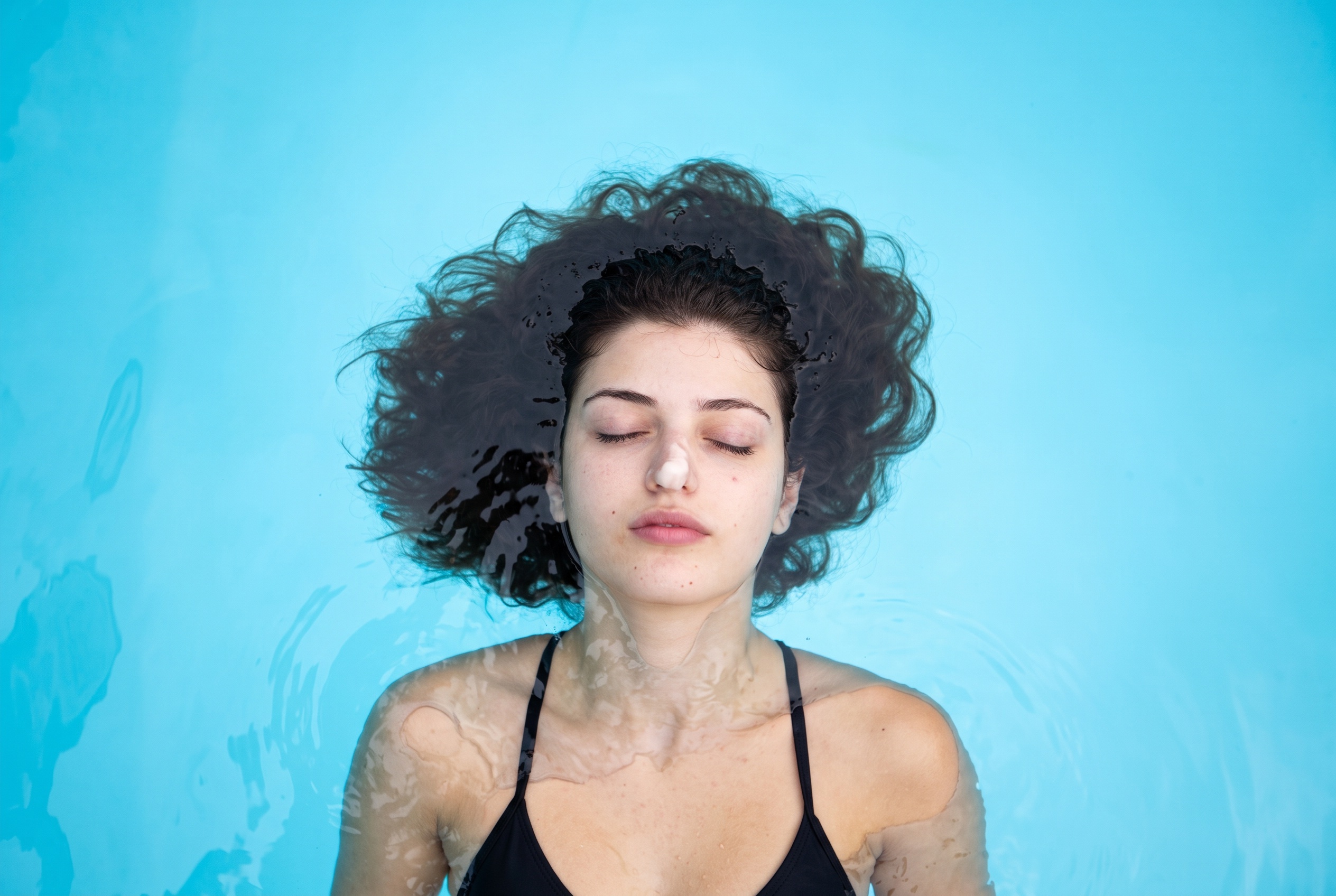 Woman floating peacefully in the water during a healing ceremony